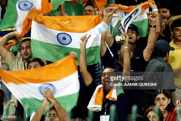 Indian cricket supporters wave their countries flags as they celebrate their team's victory at the end of the fourth One Day International match...