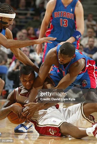 Dajuan Wagner of the Cleveland Cavaliers wrestles for a loose ball with Lindsey Hunter of the Detroit Pistons at Gund Arena on March 21, 2004 in...