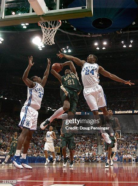 Tony Johnson of the UAB Blazers drives for a shot attempt between Antwain Barbour and Kelenna Azubuike of the Kentucky Wildcats as the Blazers upset...