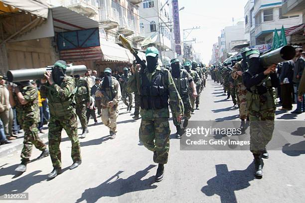 Masked Hamas members attend the funeral of Hamas Founder Sheikh Ahmad Yassin on March 22, 2204 in Gaza City, Gaza Strip. Yassin was targeted and...