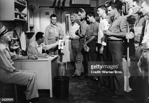 American actors William Powell, , Henry Fonda , Jack Lemmon and Ward Bond talk to a group of US Naval officers in a still from the film 'Mister...