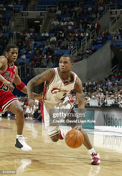 Djuan Wagner of the Cleveland Cavaliers drives by Kendall Gill of the Chicago Bulls during the game at Gund Arena on March 16, 2004 in Cleveland,...