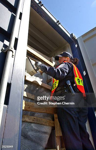 Customs inspector uses a radiation isotope identifier on freight in a shipping container during an examination at the docks March 22, 2004 in Jersey...