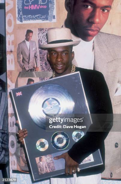 American R&B singer Bobby Brown holding a copy of his album 'Don't Be Cruel', at the HMV shop, circa 1988.