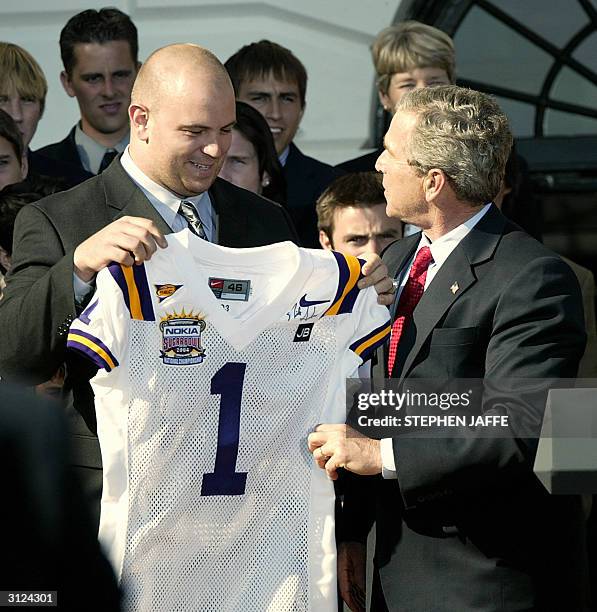 President George W. Bush is presented a football jersey from Louisiana State University football player Rodney Reed on the South Lawn of the White...