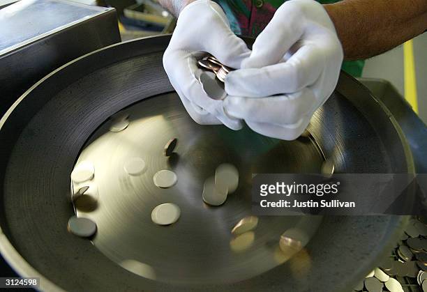 Worker uses a machine to separate coin blanks at the U.S. Mint March 23, 2004 in San Francisco, California. The San Francisco Mint opened in 1937 and...