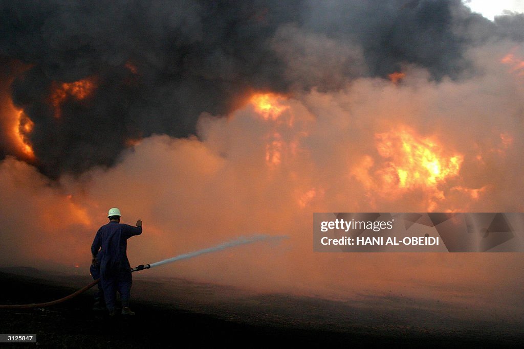 An Iraqi fireman fights the flames that