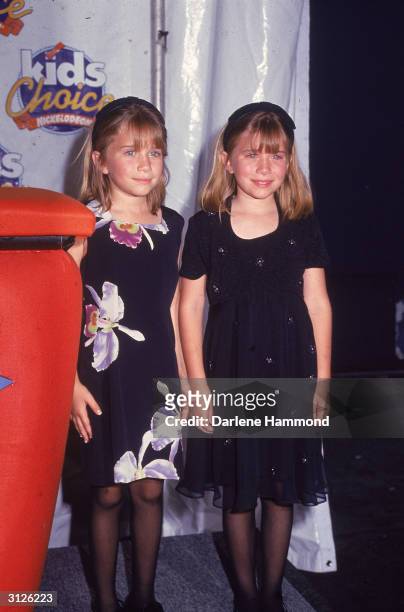 American twin child actors Mary-Kate and Ashley Olsen smile at the Nickelodeon Kid's Choice Awards, May 11, 1996.
