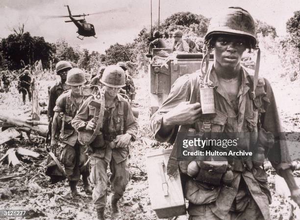 After receiving a fresh supply of ammunition and water flown in by helicopter, men of the US 173rd Airborne Brigade continue on a jungle 'Search and...