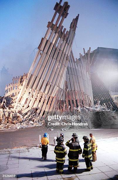 New York City firefighters look at the detroyed facade of the World Trade Center September 13, 2001 two days after the twin towers were destroyed...