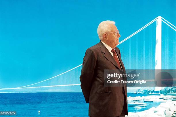 Giuseppe Zamberletti, president of the "Stretto di Messina" company, stands in front a simulation photo of the planned bridge over the Strait of...