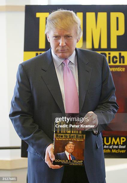 Donald Trump poses with a copy of his new book "How To Get Rich" during a book signing March 24, 2004 at Barnes and Noble in Lincoln Center in New...