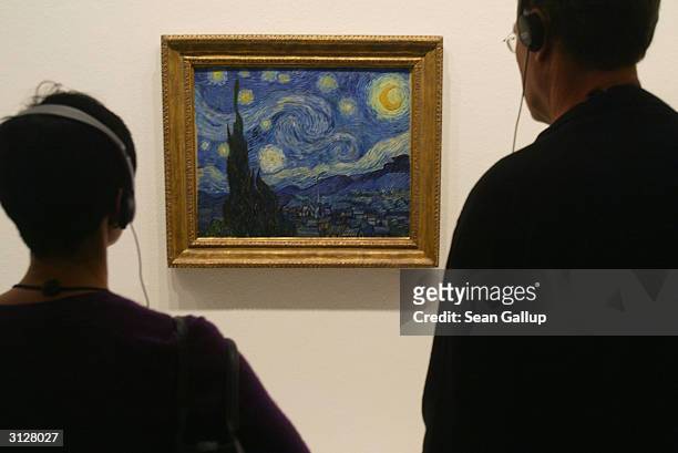 Visitors take a look at Vincent van Gogh's "Starry Night" at the MoMA exhibit, on March 24, 2004 in Berlin, Germany. The exhibit, which opened...