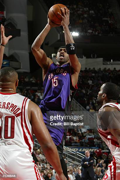 Vince Carter of the Toronto Raptors shoots over Clarence Weatherspoon of the Houston Rockets as the Rockets defeated the Raptors 90-89 in OT on March...