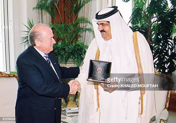 The emir of Qatar Qatar Sheikh Hamad bin Khalifa al-Thani and Sepp Blatter, president of the football's international ruling body FIFA, shake hands...