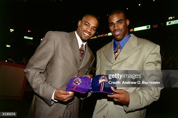 Vince Carter of the Toronto Raptors and Antawn Jamison of the Golden State Warriors pose with their new team's hats on June 24, 1998 during the 1998...