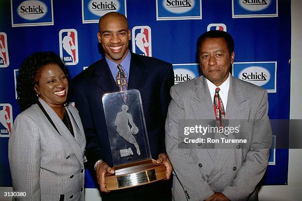 Vince Carter of the Toronto Raptors, center, poses with his parents for a photo with trophy in hand circa 1999 after being named 1998-1999 NBA Rookie...