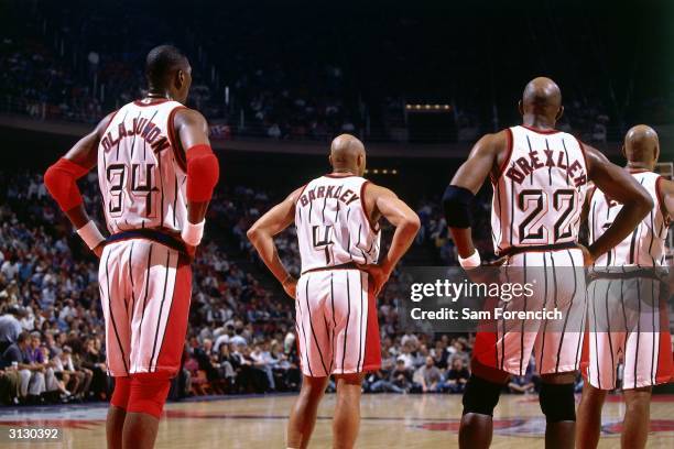 Hakeem Olajuwon, Charles Barkley and Clyde Drexler of the Houston Rockets look on during a break in NBA game action circa 1997 in Houston, Texas....