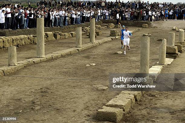 Torchbearer Sergey Bubka, former Olympic pole vaulter, carries the Olympic Flame into the ancient Theatre of Ilidas during the Greek portion of the...