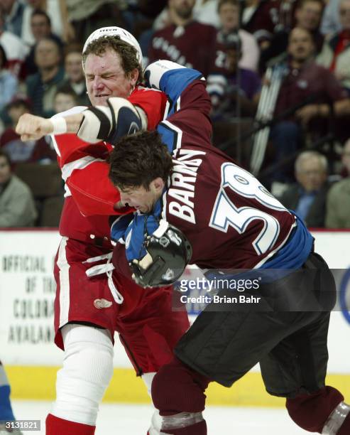 Darren McCarty of the Detroit Red Wings takes a swing at Matthew Barnaby of the Colorado Avalanche as they square off for a fight in the first period...
