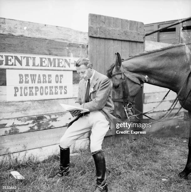 Man standing in front of a sign warning of pickpockets at the Peterborough agricultural show while a horse rummages through his pockets.