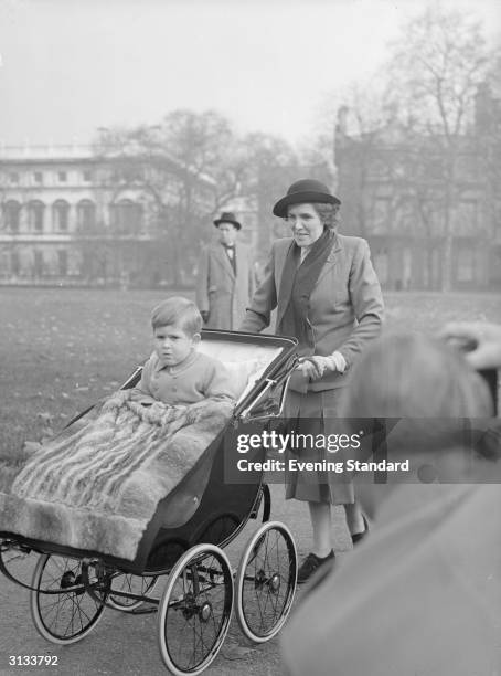 Nurse Helen Lightbody takes Prince Charles out for some fresh air in Green Park, London.
