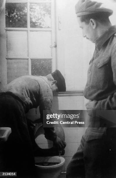 Jewish troops supervise the German inmates at a prisoner-of-war camp near Haarlem. The prisoners are put to work keeping the camp clean, as well as...