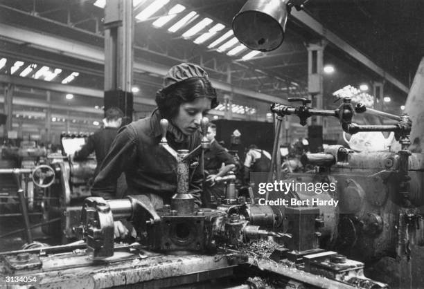 Female worker manufacturing guns in a munitions factory in Britain during World War II. Original Publication: Picture Post - 761 - They Make The Guns...