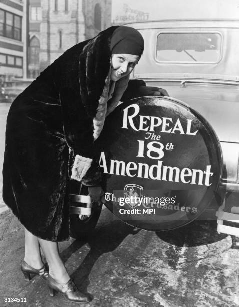 Woman with a sign on the back wheel of her car supporting the repeal of the 18th Amendment, , which made the sale and possession of alcohol illegal.