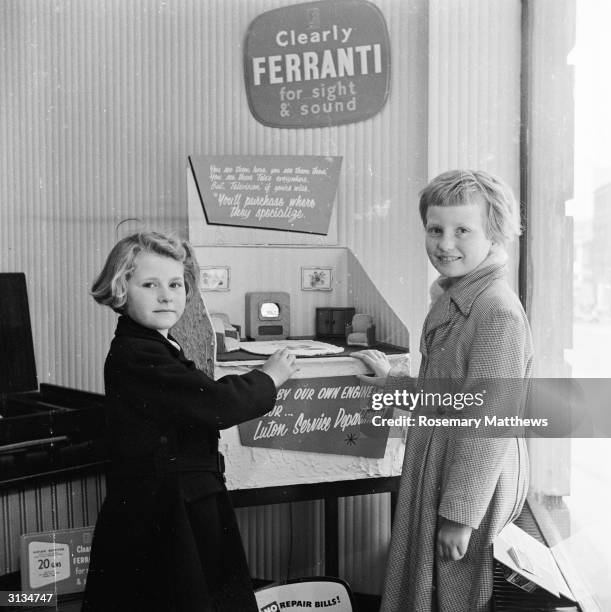 Children admire a tiny television set made by Luton radio dealer Charles Wilson for use in a doll's house and on display in his shop window. The TV...