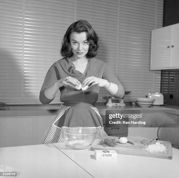 British film actress Anne Heywood mixing the ingredients for a low calorie vegetarian hamburger which she has invented.