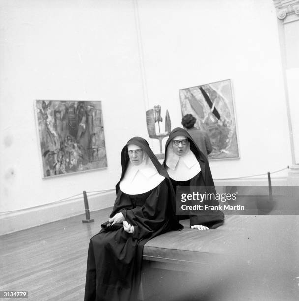 Nuns at an exhibition of modern art, organised by the Contemporary Art Society on the theme of religion, in London's Tate Gallery. The sculpture in...