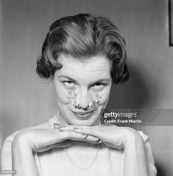 Londoner Carol Snape modelling a spray of mother-of-pearl flowers which can be worn singly or in pairs.