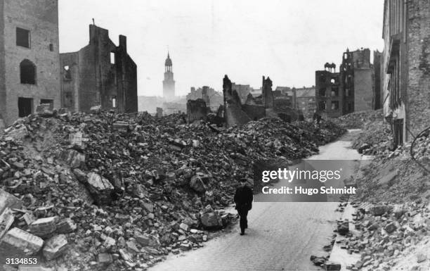 Solitary figure walking through a devastated area of Hamburg during World War II.