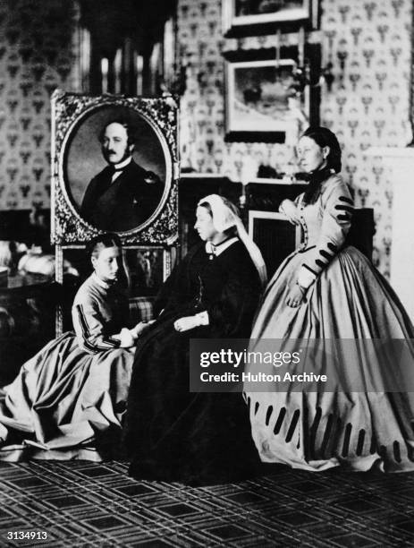 Queen Victoria at Balmoral with her daughters, Princess Alice and Princess Louise, Duchess of Argyll, and a portrait of her late husband, Prince...