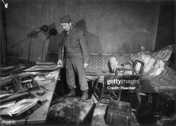 Private First Class Richard Blust of Michigan surveys the bunker at the German Reichschancellery in Berlin where Adolf Hitler and his wife Eva Braun...