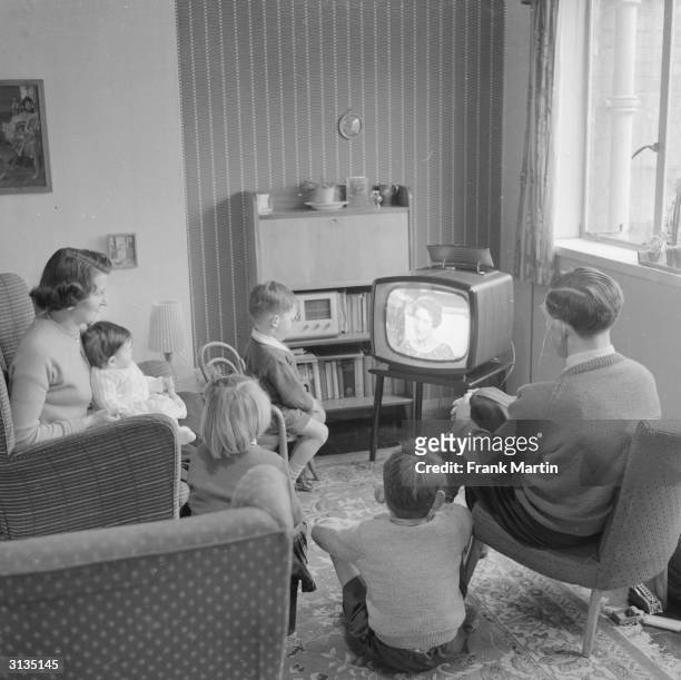Joan Evans watches television with her husband and four children at their new home in the new town of Harlow, Essex.
