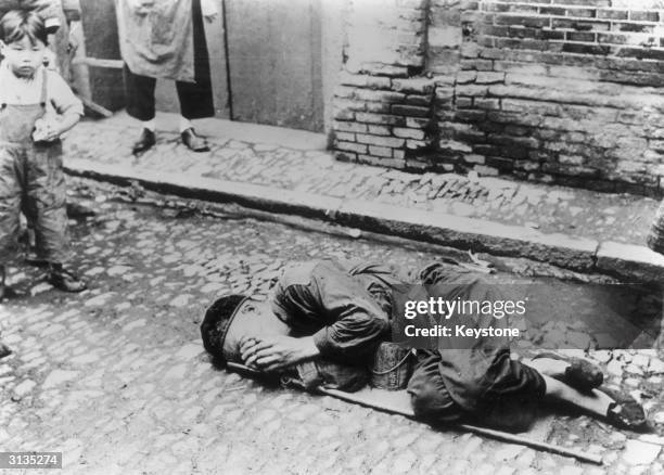 The soup can remains empty underneath the dead body of an elderly Chinese man who has died of starvation.