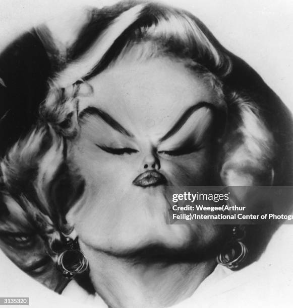 American movie actress and sex symbol Marilyn Monroe with her features sucked into the middle of her face by Weegee's plastic lens.