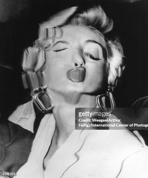 American movie actress and sex symbol Marilyn Monroe with her expression blurred and distorted by Weegee's plastic lens.