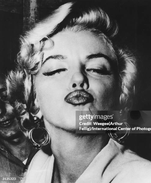 American movie actress and sex symbol Marilyn Monroe blows a pouting kiss.