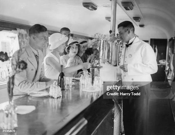 Passengers drinking in the new buffet car of a Great Western Railway train.