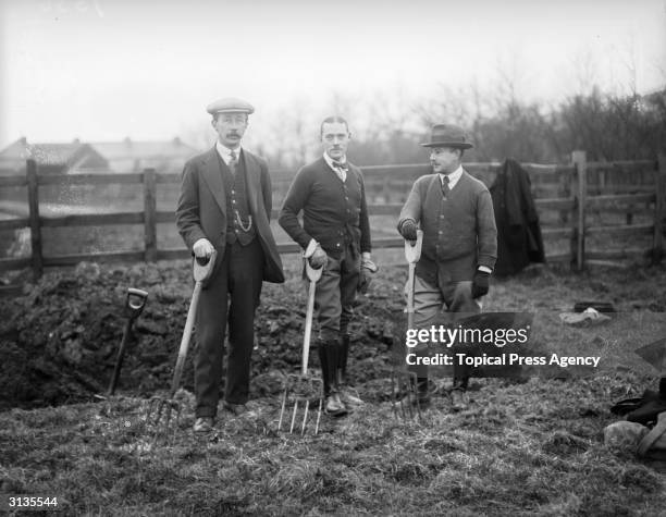 Allotment holders with their garden forks ready to dig over their allotments, at Ilford, Essex.