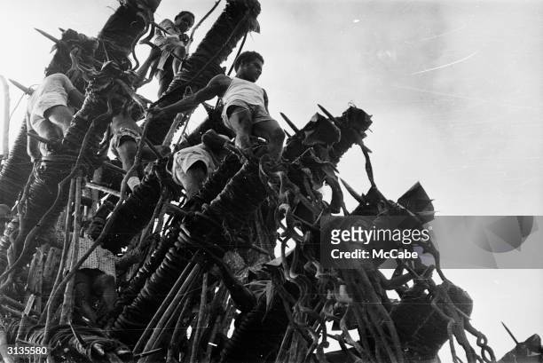 Group of young men prepare to perform a land dive from a bamboo platform during a visit by Queen Elizabeth and Prince Philip to Pentecost Island,...