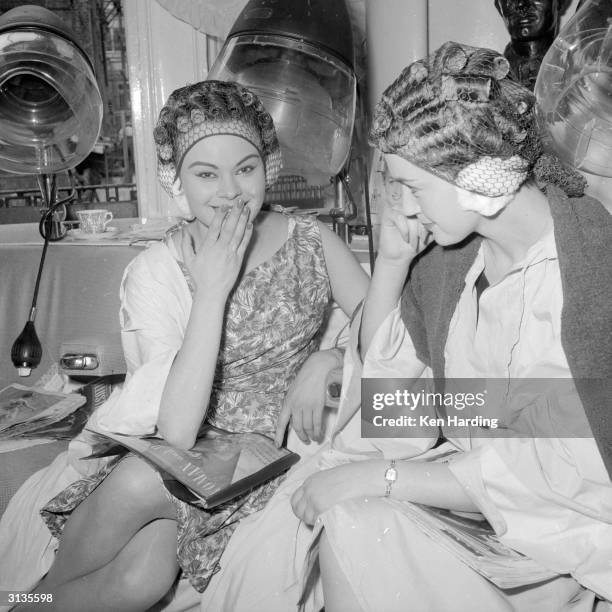 Models Pamela Searle and Jean Binfield at Raymond's Hairdresser's of Grafton Street, London. Raymond uses 'hairology' to forecast his customer's...