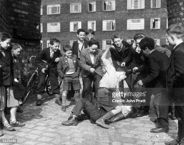 Boys scrambling beside blocks of housing in a deprived area of Liverpool. They are members of the Rodney Youth Centre, known as 'The Street Corner...