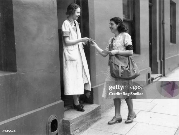 Mrs K Foster takes over the job of a postal worker in Luton during World War II. She and the other volunteers wear armbands reading 'Post Office...