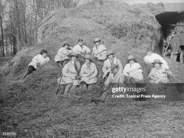 Women during training to be Land Girls take a break in a haystack.