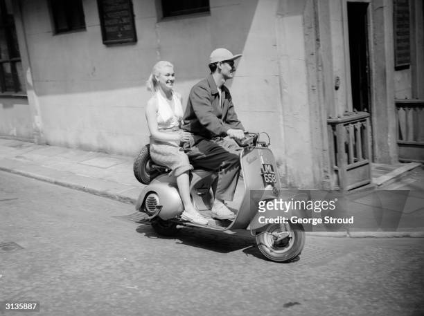 Actor and former acrobat Bonar Colleano and English actress Susan Shaw on a Vespa scooter.