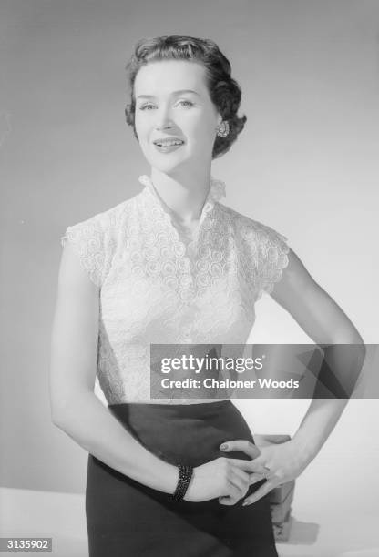 Woman modelling a short-sleeved white lace blouse.